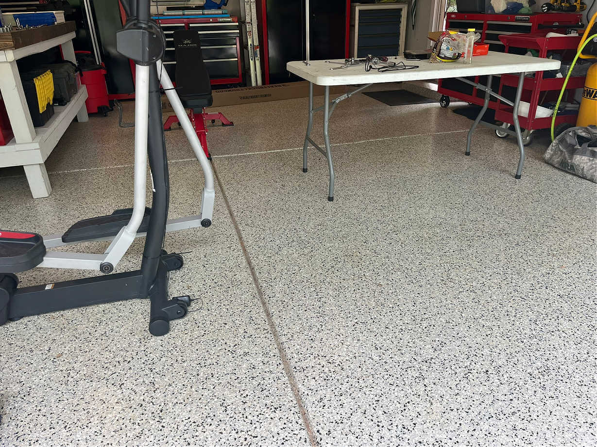 A garage floor with an epoxy flake coating to protect the surface.